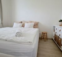 ŠTÝLOVÝ 2i BYT, REKONŠTRUKCIA, BALKÓN, KLÍMA, Murgašová ulica - Svetlá spálňa s posteľou a komodou, podlaha s dreveným dekorom, 2-izbový byt.