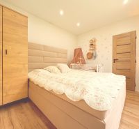 Na predaj: CENTRUM  3 izb.byt + BALKON + ŠPAJZA  - Spálňa v 3-izbovom byte s posteľou a skriňou, podlaha s dreveným dekorom.