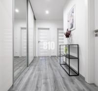 TOP! 4 izb. byt, balkón, 100 m2 (šatník, 2x toaleta, 3x klíma, zariade - Svetlá chodba v 4-izbovom byte s podlahou s dreveným dekorom a elegantným nábytkom.