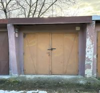 PREDAJ – Garáž na predaj v meste Galanta za kaštieľom - Garáže v Galante s kovovými dverami a opotrebovanými fasádami, obklopené stromami.