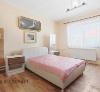 RODINNÝ DOM - CHALUPA S VEĽKÝM POZEMKOM | SKÝCOV - Spálňa v rodinnom dome s posteľou, obrazmi a podlahou s dreveným dekorom.