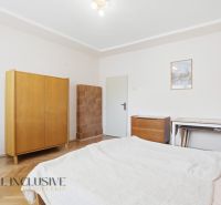 RODINNÝ DOM - CHALUPA S VEĽKÝM POZEMKOM | SKÝCOV - Spálňa v rodinnom dome s podlahou s dreveným dekorom, skriňou a kachľovou pecou.