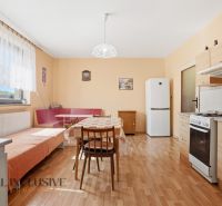 RODINNÝ DOM - CHALUPA S VEĽKÝM POZEMKOM | SKÝCOV - Kuchyňa v rodinnom dome s podlahou s dreveným dekorom, jedálenským stolom a spotrebičmi.