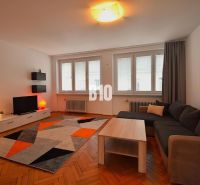 NA PRENÁJOM Priestranný 3 izbovy byt Žilina  - centrum mesta , FOR REN - 3-izbový byt s podlahou s dreveným dekorom, šedou sedačkou a pestrofarebným kobercom.