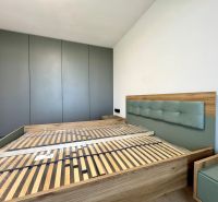 REZERVOVANÝ Na prenájom 2i luxusný zariadený byt na Terase - Spálňa v 2-izbovom byte s posteľou a vstavanou skriňou, podlaha s dreveným dekorom.