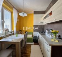 PREDANÉ- 2 izbový byt s balkónom blízko centra mesta Humenné - Kuchyňa v 2-izbovom byte s podlahou s dreveným dekorom a žltými stenami.