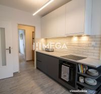 Na predaj - 3izbový byt s pozemkom a garážou v meste Humenné - Kuchyňa 3-izbového bytu s podlahou s dreveným dekorom a svetlým obkladom.