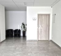 PRENÁJOM komerčného priestoru (26 m2) blízko centra Humenné - Interiér obchodných priestorov s kreslami, dlažbou a dverami s dreveným dekorom.