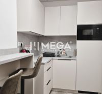 PRENÁJOM komerčného priestoru (26 m2) blízko centra Humenné - Kuchyňa v obchodných priestoroch s minimalistickými bielymi skrinkami a pultom na sedenie.