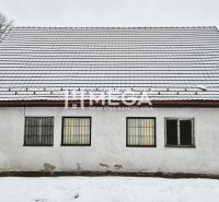 Predaj budovy v obci Zboj - Snehom pokryté obchodné priestory v meste Zboj s jednoduchou fasádou a mriežkami na oknách.