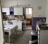 Znížena cena domu na Jesenského ulici v Snine - Kuchyňa v rodinnom dome s fialovými skrinkami a jedálenským stolom.