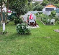 Znížena cena domu na Jesenského ulici v Snine - Záhrada rodinného domu na Jesenského ulici v Snine s altánkom a rastlinami.