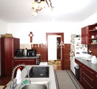 TOP CENA NA PREDAJ UNIKÁTNY RODINNÝ DOM MEDZILABORCE - Kuchyňa v rodinnom dome s dreveným dekorom skríň a vybavením spotrebičmi.