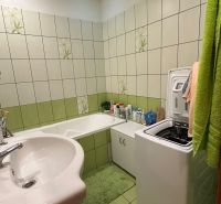 Na predaj 3-izbový byt Levice, 61m2 - Kúpeľňa s vaňou a práčkou v 3-izbovom byte; bežové a zelené obklady.