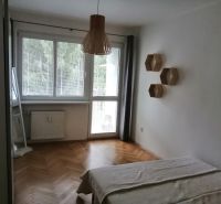 PRENÁJOM: ÚTULNÝ 2 IZBOVÝ BYT S BALKÓNOM, UHLISKO - Spálňa s podlahou s dreveným dekorom a veľkým oknom v 2-izbovom byte.