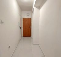 PRENÁJOM: ÚTULNÝ 2 IZBOVÝ BYT S BALKÓNOM, UHLISKO - Úzka chodba s bielymi stenami a svetlou dlažbou v 2-izbovom byte.