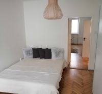 PRENÁJOM: ÚTULNÝ 2 IZBOVÝ BYT S BALKÓNOM, UHLISKO - Spálňa v 2-izbovom byte s posteľou, bielou stenou a podlahou s dreveným dekorom.
