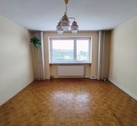 Na predaj priestranný 3-izbový byt s garážou v Nitre – Chrenová - Izba so zaveseným svetlom a podlahou s dreveným dekorom v 3-izbovom byte.