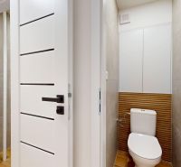 2- izbový byt, ktorý voní novotou, Kompletne zrekonštruovaný. - Toaleta s dlaždicovým obkladom a bielym zariadením v 2-izbovom byte.