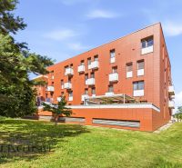 Na predaj 1-izb. s vlastným park. státím, Bratislava  - Budova s balkónmi a zeleňou v Bratislave - Záhorskej Bystrici, ideálna pre 1-izbový byt.