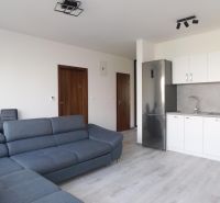 Moderný 2-izbový byt na prenájom-Hviezdoslavov–parkovanie,klimatizácia - Obývačka s kuchyňou v 2-izbovom byte, sivá sedačka, biela kuchynská linka.
