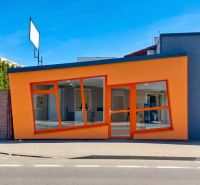 Obchodný priestor 75m2 | Zlatovská, Trenčín - Oranžová fasáda obchodných priestorov na Zlatovskej ulici v Trenčíne s veľkými sklenenými oknami.