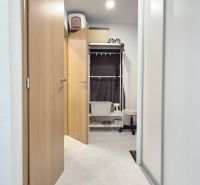 MODERNÝ DVOJIZBOVÝ BYT, 37M2, DÚBRAVKA - Chodba v 2-izbovom byte s dlažbou, vstavanými skriňami a otvorenými dverami vedúcimi k úložnemu priestoru.
