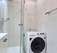 MODERNÝ DVOJIZBOVÝ BYT, 37M2, DÚBRAVKA - Kúpeľňa v 2-izbovom byte s práčkou, sprchovým kútom a svetlými obkladmi.