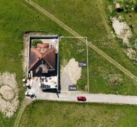 Iba 10km od Žiliny - STAVEBNÝ POZEMOK - Lietavská Svinná - Lietavská Svinná-Babkov: Parcelka pre bývanie, zelená lúka s rozostavaným domom a vozidlami.
