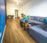 | Srdce Mesta | 2 Izb. byt | ORBIS |  70 m2 - Obývacia izba s podlahou s dreveným dekorom a modrou stenou v 2-izbovom byte.