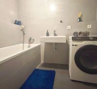 | Srdce Mesta | 2 Izb. byt | ORBIS |  70 m2 - Kúpeľňa v 2-izbovom byte s vaňou, umývadlom a práčkou na podlahe s dlažbou.