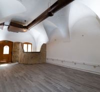 Meštiansky dom v centre Banskej Bystrice a parkovaním pre 24 áut D135Z - Interiér budovy s bielymi klenbami, dverami a podlahou s dreveným dekorom.