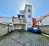 Meštiansky dom v centre Banskej Bystrice a parkovaním pre 24 áut D135Z - Budova na Dolnej ulici 28 v Banskej Bystrici s parkoviskom a kamenným múrom.