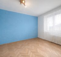 Na predaj 3-izbový byt s loggiou – Žiar nad Hronom, ul. D. Hrdinov - Izba v 2-izbovom byte s modrou stenou a podlahou s dreveným dekorom.