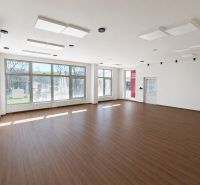 Prenájom obchodných, kancelárskych  priestorov – Banská Bystrica - Veľké obchodné priestory s podlahou s dreveným dekorom a veľkými oknami.