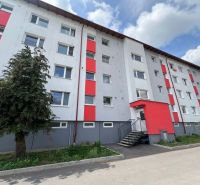Na prenájom 2-izbový byt s veľkou loggiou v obci Slovenská Ľupča - Bytový dom na ulici Za Nožiarňou, Slovenská Ľupča, s výraznými červenými panelmi.