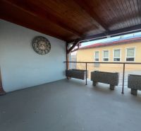 Prenájom skladové priestory s kanceláriami od 200 m² – Banská Bystrica - Krytá terasa s hodinami a kvetináčmi vo výrobných priestoroch.