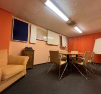 Sklad + kancelárie 1349 m² logistický objekt s rampami -Banská Bystria - Konferenčná miestnosť s oranžovými stenami, stoličkami, bielou tabuľou a flipchartom.