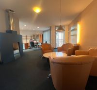 Sklad + kancelárie 1349 m² logistický objekt s rampami -Banská Bystria - Interiér výrobných priestorov s krbom, koženými kreslami a konferenčným stolíkom.
