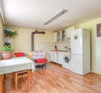 6-izbový rodinný dom v obci Biely Kostol - Kuchyňa v rodinnom dome s podlahou s dreveným dekorom a rastlinami na parapete.