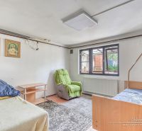 6-izbový rodinný dom v obci Biely Kostol - Izba s posteľami, koberec, kreslo a náboženské obrazy v Rodinnom dome.