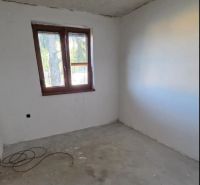PREDAJ : 3 IZBOVÝ BYT V ZEMIANSKEJ OLČI  - Nedokončená izba s oknom v 3-izbovom byte, svetlá stena a betónová podlaha.