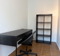 Prenájom 3-izb. byt Ku Bratke - zariadený - Pracovňa v 3-izbovom byte s čiernym stolom, poličkou a hnedou podlahou.