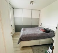 Na predaj 3.izb.byt v Petržalke pri novej elek.trati.65m2 - Spálňa v 3-izbovom byte s podlahou s dreveným dekorom a veľkou skriňou.