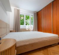 2 izbový kompletne zariadený byt Sever na prenájom - Spálňa v 2-izbovom byte s podlahou s dreveným dekorom a vstavanou skriňou.