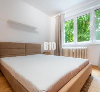 2 izbový kompletne zariadený byt Sever na prenájom - Spálňa v 2-izbovom byte s veľkým oknom a podlahou s dreveným dekorom.