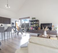 NA PREDAJ 4 IZBOVÝ RODINNÝ DOM - NOVOSTAVBA, ŠAMORÍN - Obývačka rodinného domu, kuchyňa s jedálňou, drevené podlahy, svetlé steny, izbové rastliny.