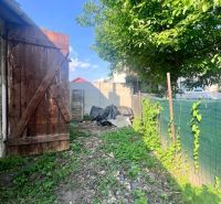 Na predaj vidiecky rodinný dom - Žarnovica/Brehy D045ZL - Záhrada rodinného domu v Brehoch, Nová Baňa, s drevenou bránou a stromom.