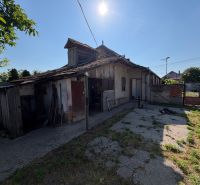 Rodinný dom s veľkým pozemkom v meste Nesvady  - Rodinný dom v Nesvadoch s poškodenou strechou a slnečným dvorom.