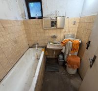 Rodinný dom s veľkým pozemkom v meste Nesvady  - Kúpeľňa v rodinnom dome s vaňou, umývadlom a béžovými kachličkami na stenách.
